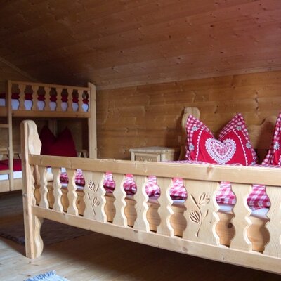 Schlafzimmer im Hof mit Doppelbett, Stockbett und Holzverkleidung.